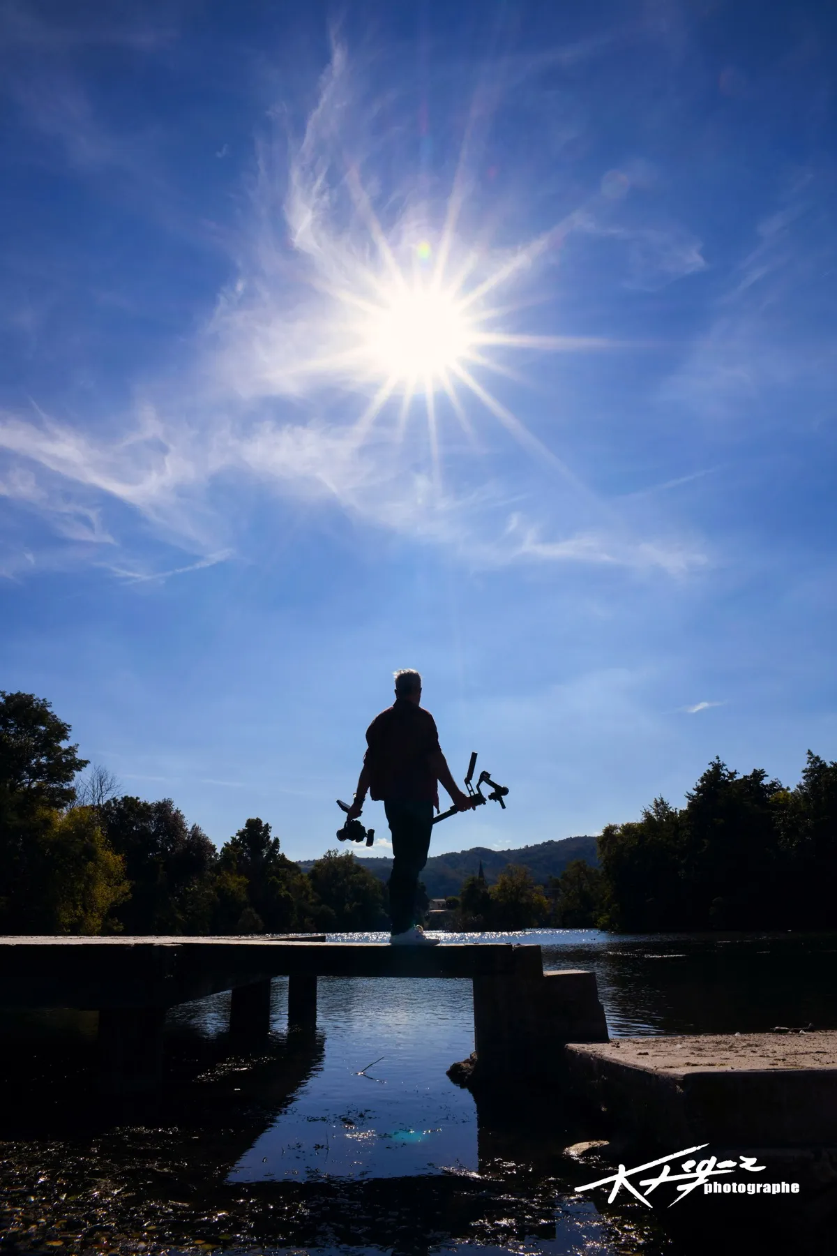 Laurent Dimberton en tournage, silhouette à contre-jour au bord de l'eau